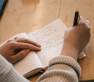 A person taking notes in a notebook.