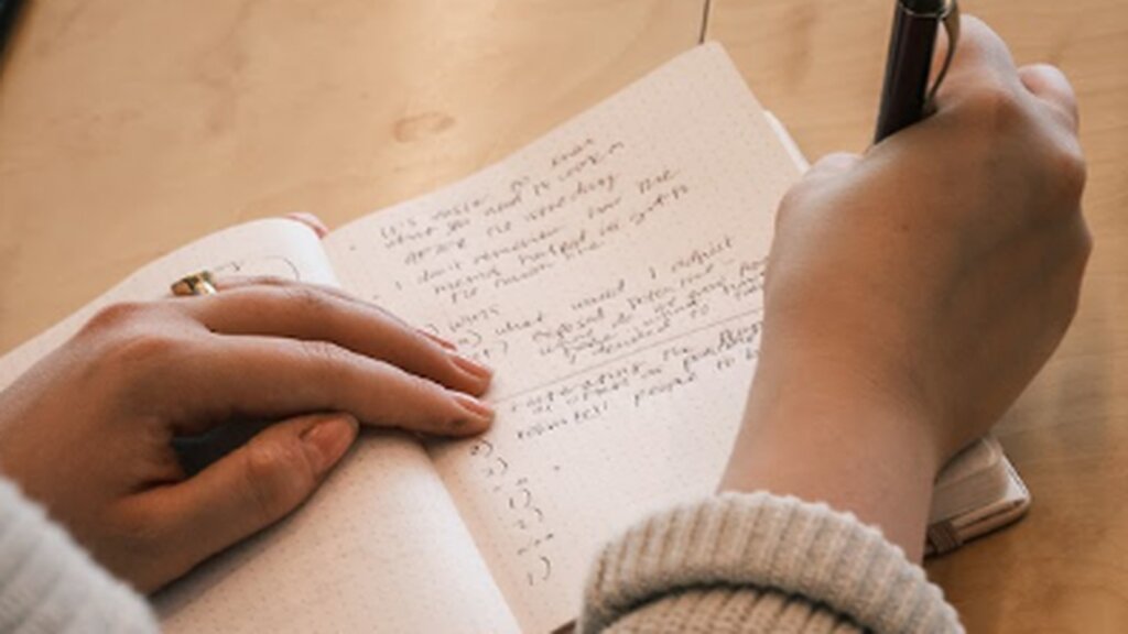 A participant taking handwritten notes during a learning session.